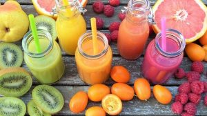 Vitamin c fruits in colors and juices in the middle