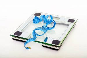 diet indicated by a weight scale with a measuring tape on it