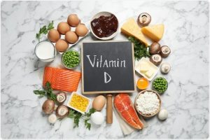 "Vitamin D" written on a chalkboard in the middle of vitamin D-rich food
