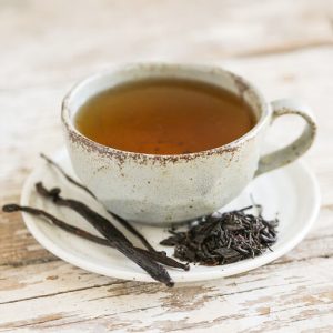 Vanilla infused tea in teacup with vanilla beans